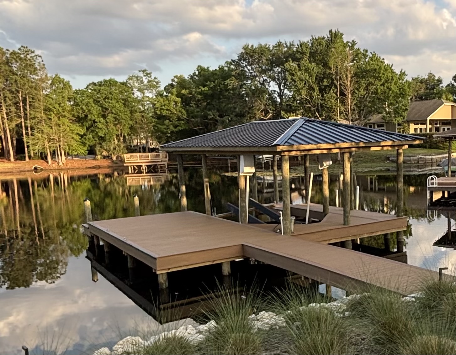 Covered boat dock with metal roof on a calm lake